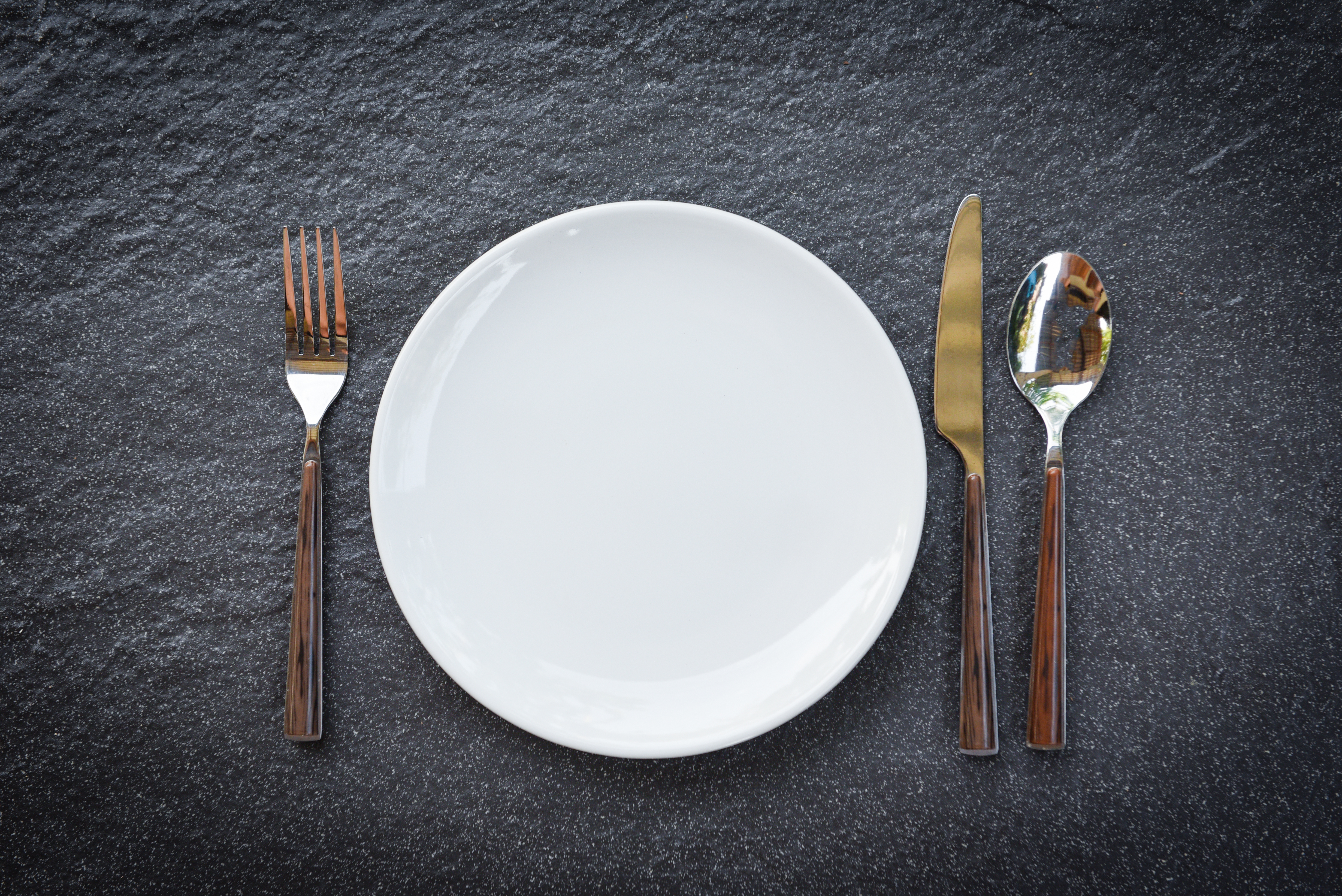 Place setting table food with set of white plate on table cloths or napkin on the dinner / empty plate spoon fork and knife on table , top view